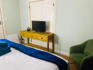 Johannesburg的住宿－Afrikawisa@Rosebank，一间卧室配有一张床和一张桌子上的电视