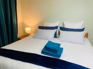 un letto bianco con cuscini blu e bianchi di Afrikawisa@Rosebank a Johannesburg