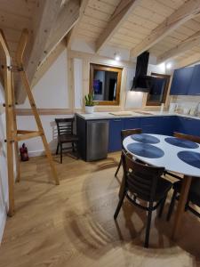 eine Küche und ein Esszimmer mit einem Tisch und Stühlen in der Unterkunft Domki u Stefana in Józefów