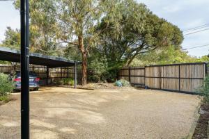 a garage with a car parked next to a fence at Karinya - Luxurious soul sanctuary by the surf. in Rye