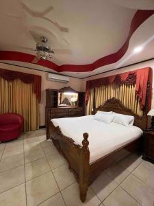 a bedroom with a large bed with a ceiling at Casa primavera Quepos in Quepos