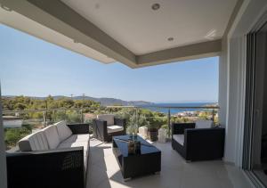 薩拉米斯的住宿－Beautiful lux Villa Ilias Salamina，阳台配有沙发,享有海景