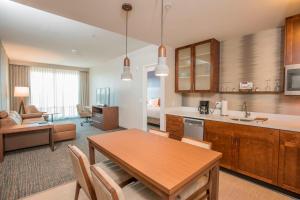 a kitchen and living room with a table and a dining room at Residence Inn by Marriott Cincinnati Midtown/Rookwood in Cincinnati