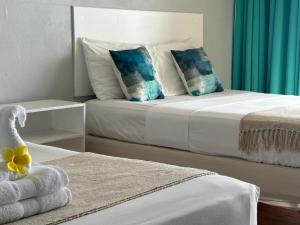una camera con 2 letti con cuscini blu e bianchi di Point Bay Resort a Calliaqua