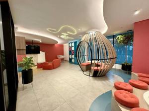 キトにあるHarmony Staysの赤い壁と金属製の球体がある部屋のあるロビー