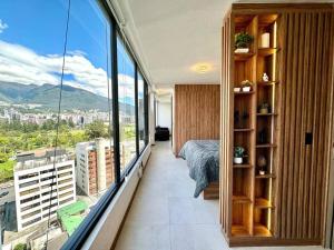 キトにあるHarmony Staysのベッドと大きな窓のある寝室