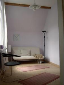 een woonkamer met een witte bank en een lamp bij Waldhaus in Wernigerode
