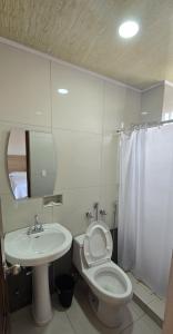 a bathroom with a white toilet and a sink at Hotel Internacional de Colón in Colón