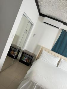 1 dormitorio con cama blanca y espejo en R & A turquoise Rental en Providenciales