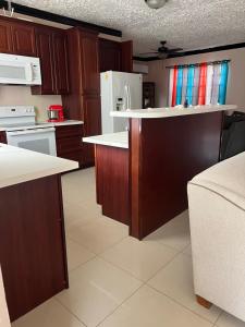 uma cozinha com armários de madeira e electrodomésticos brancos em R & A turquoise Rental em Providenciales