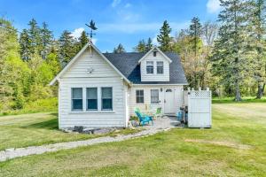 una pequeña casa blanca con patio en Quaint Maine Coast Cottage, en Saint George