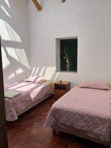 a bedroom with two beds and a window with a deer in it at Contando Historia in Potosí