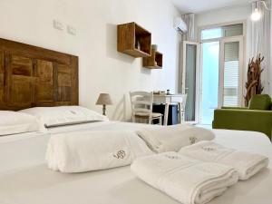 2 bedden in een slaapkamer met witte lakens en handdoeken bij Salto Nel Blu in Leverano
