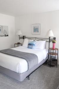 a large white bed in a room with two tables at The Landmark Inn on Orcas Island in Eastsound