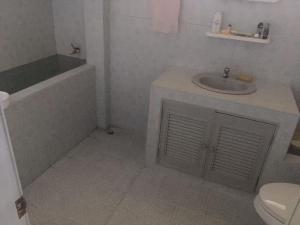 a bathroom with a sink and a tub and a toilet at The Jeffy Pool Villa in Chanthaburi