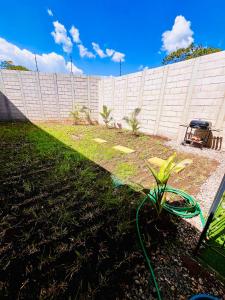 a fence with a green hose in a yard at Sun Shine Entire Home Santa Ana in Santa Ana