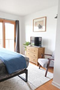 a bedroom with a bed and a tv and a chair at The Landmark Inn on Orcas Island in Eastsound