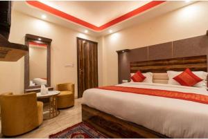 a hotel room with a large bed and a chair at THE RED DIAMOND NEAR IGI AIRPORT new DELHI in New Delhi