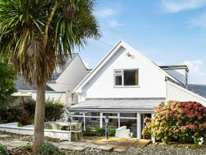 a white house with a palm tree and a patio at Ffin Yr Afon - Ukc6907 in Towyn