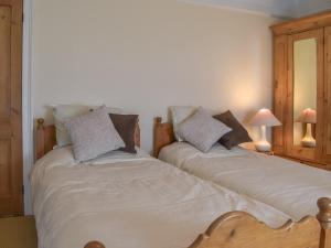 dos camas sentadas una al lado de la otra en un dormitorio en Waterside Cottage en Saltash