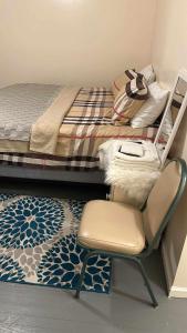 una camera da letto con una sedia accanto a un letto di Room J Divine Villa and Resorts 5mins to EWR Airport and 4mins to Penn Station Newark, New York a Newark