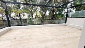 un balcone vuoto con pavimento in legno e pareti in vetro di Hermoso apartamento con terraza! Punta Carretas a Montevideo