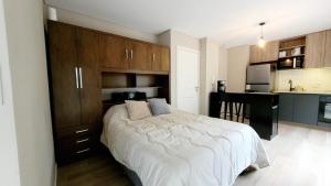 a bedroom with a large bed and a kitchen at Hermoso apartamento con terraza! Punta Carretas in Montevideo