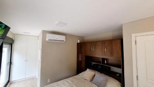 1 dormitorio con 1 cama y pared con microondas en Hermoso apartamento con terraza! Punta Carretas, en Montevideo