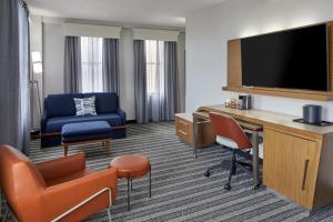 a hotel room with a desk and a tv at Courtyard by Marriott Nashville Downtown in Nashville