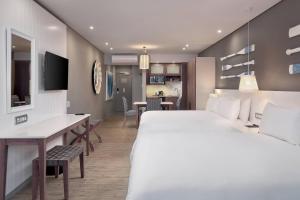 a hotel room with a large bed and a desk at Protea Hotel by Marriott Durban Umhlanga in Durban