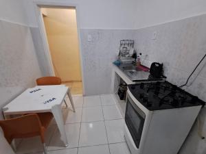a small kitchen with a stove and a sink at Casa com 2 quartos mobiliada in Rio de Janeiro