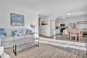 uma sala de estar com um sofá branco e uma mesa em Ocean View East Duplex with Walk to Crescent Beach em Owls Head