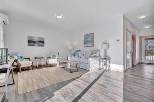 a living room with a couch and a table at Ocean View East Duplex with Walk to Crescent Beach in Owls Head