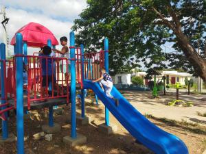 a group of children playing on a playground at Malvar Lodge in San Isidro Sur