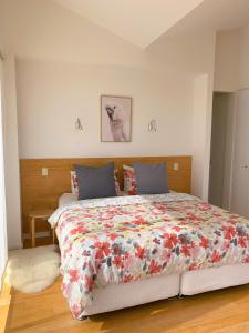 ein Schlafzimmer mit einem großen Bett mit einer bunten Bettdecke in der Unterkunft Lush Pastures in Bald Hills
