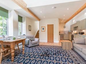 a living room with a table and a kitchen at The Old Stable in Dursley