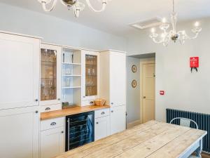 a kitchen with white cabinets and a wooden table at The Old Manse - Ukc6854 in Millton of Clova