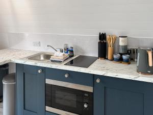 a kitchen counter with a sink and a microwave at Bombie Glamping Pod in Cromdale