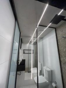 a bathroom with a white toilet and a mirror at Flat beira mar de Cabo Branco em João Pessoa Setai YACHT in João Pessoa