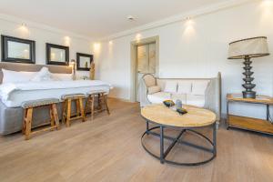 a bedroom with a bed and a couch and a table at Kampenkliff ehemals Walter´s Hof in Kampen