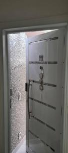 uma porta branca com um chuveiro na casa de banho em Apto. inteiro c/ Piscina no Portal Ipês Cajamar SP em Cajamar