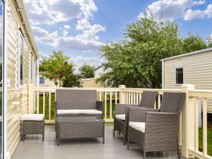 a patio with wicker chairs on a deck at Summer Willow Lodge in Tattershall