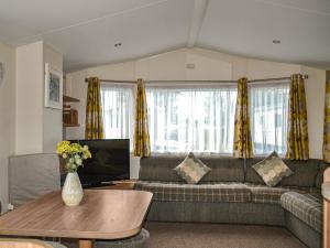 a living room with a couch and a table at Summer Willow Lodge in Tattershall