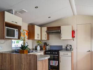 a kitchen with white cabinets and a stove top oven at Summer Willow Lodge in Tattershall