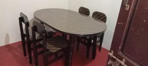 a table with four chairs and a table and a table and chairsuggest at Hallima Residency Non Ac in Pudukkottai