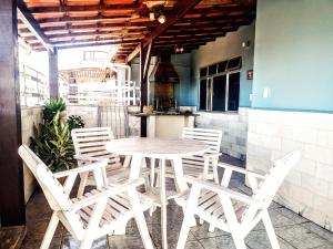 un tavolo bianco e sedie su un patio di Cobertura com área Goumet- 4 quartos a Cabo Frio