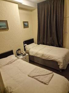 a hotel room with two beds and a window at Winston House in Bridlington