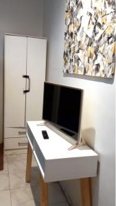 einen weißen Schreibtisch mit einem TV darüber. in der Unterkunft Aparta Hotel in Buenos Aires