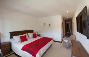 1 dormitorio con 1 cama grande con almohadas rojas en Gran Vista Panorámica inmejorable Ubicación, en Pucón