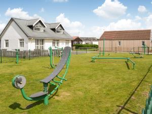 a playground with a slide and swings at Seaside Dreams in Bessingby
